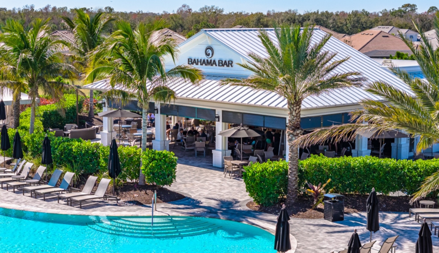 The Bahama Bar & Grill at Esplanade — the covered, palm-framed bar and patio seating beside the resort pool